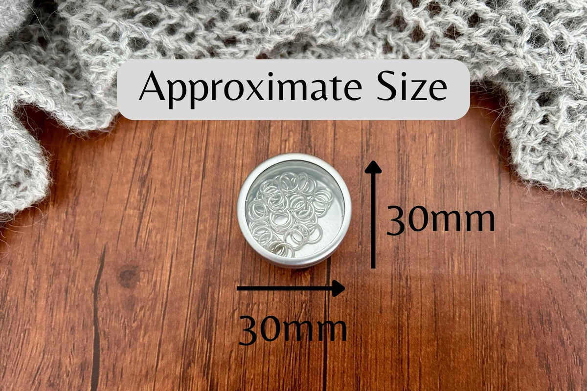 A small silver coloured pot with a window lid containing 40 snag free knitting stitch markers showing the size of the tin as 30mm x 30mm