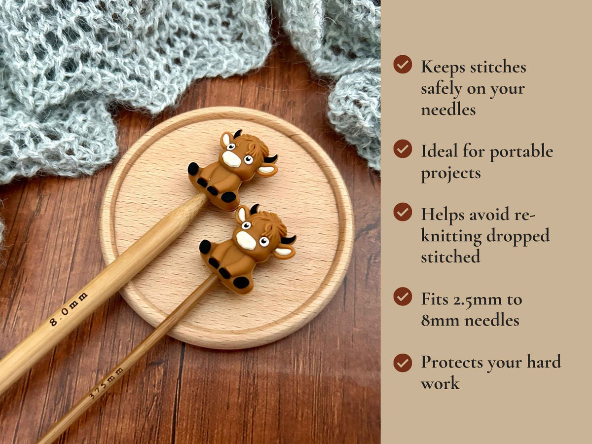 A promotional graphic for a knitting needle stoppers, showing two wooden knitting needles with brown cow-shaped guards on them, resting on a round wooden tray. The background features a gray knitted cowl and a text overlay on the right detailing the benefits of the guards. Keeps stitches on needles. Ideal for portable projects. Helps avoid re-knitting dropped stitches. Fits mm to 2.5mm to 8mm needles 
 