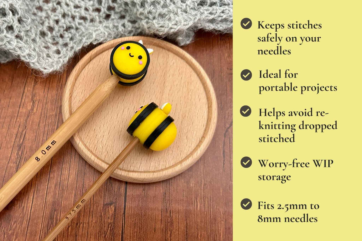 Yellow and black bee-shaped needle stoppers displayed on wooden knitting needles on a round wooden coaster, with a knitted gray fabric in the background and a yellow text panel on the right listing features. Keeps stitches on needles. Ideal for portable projects. Helps avoid re-knitting dropped stitches. Fits mm to 2.5mm to 8mm needles 

