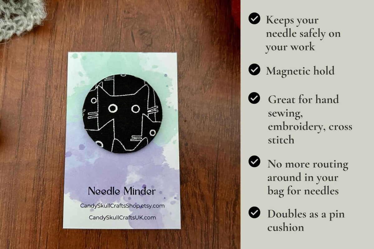 A black cat needle nanny listing graphic showing a 'Needle Minder' needle cushion on the left, placed on a wooden surface next to a text panel on the right detailing its features: magnetic hold, safety on work, great for hand sewing/embroidery/cross stitch, no routing around needles, and double as a pin cushion.