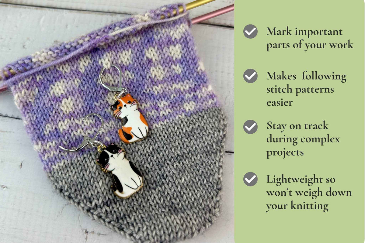 Knitting stitch markers featuring cat charms in calico and black-and-white designs, displayed on a purple and gray knitted sock next to a text panel with product benefits. Mark important parts of your work. Makes following stitch patterns easier. Removable so works for knitting and crochet. Stay on track during complex projects.
