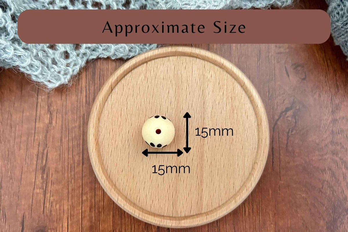 A small round knotting needle stoppers with a single red dot is shown on a round wooden tray, with overlaid arrows and text indicating approximate size 15mm by 15mm. A brown banner at the top reads 'Approximate Size'.