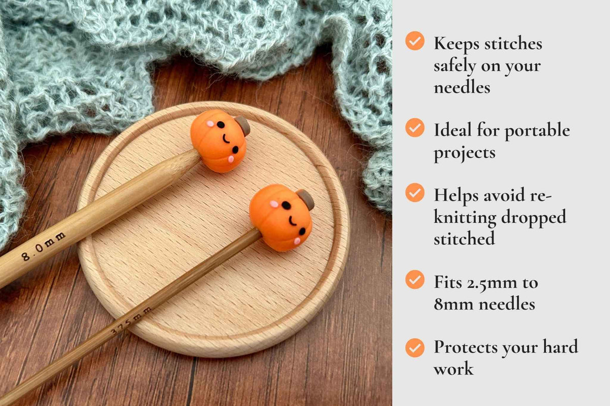 A pair of wooden knitting needles with orange pumpkin-shaped stitch protectors on the tips, displayed on a round wooden tray with a knitted green textile in the background. A text panel on the right lists benefits of the stitch protectors. Keeps stitches on needles. Ideal for portable projects. Helps avoid re-knitting dropped stitches. Fits mm to 2.5mm to 8mm needles 
