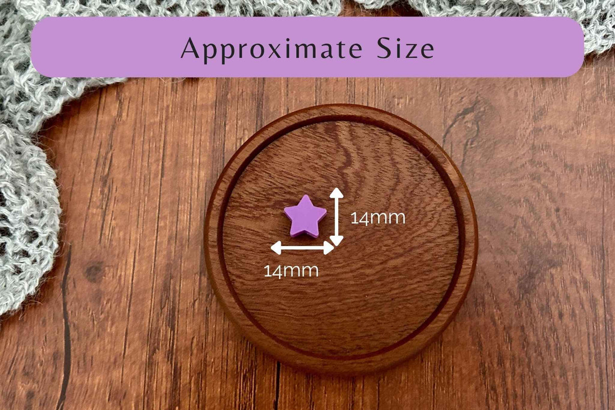 A wooden round tray or coaster on a wood-grain surface with a purple banner reading 'Approximate Size' and a small purple star-shaped knitting needle stopper marked 14mm by arrows, indicating approximate dimensions.