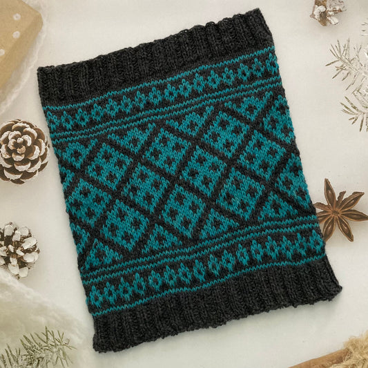 A hand knit Selbu cowl knit in dark grey and green using traditional Norwegian and Scandinavian colourwork charts