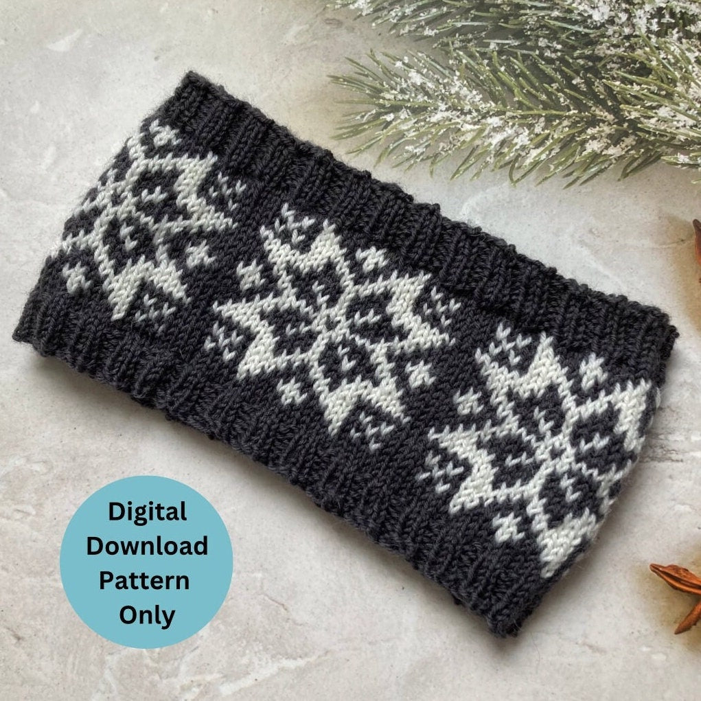 A knitted winter headband with a dark charcoal gray and off-white Nordic Selbu Star snowflake pattern, displayed on a light stone surface with a digital download pattern badge overlay.