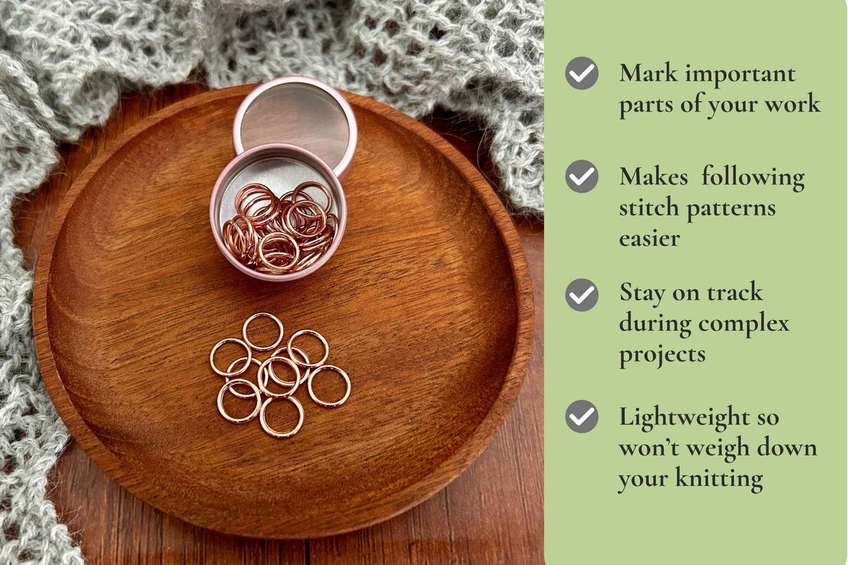 A set of small metallic knitting stitch markers displayed on a round wooden tray with a knitted gray textile nearby. A vertical light green text panel on the right lists benefits such as marking important parts of a knitting project, making stitch patterns easier to follow, staying on track, and being lightweight.