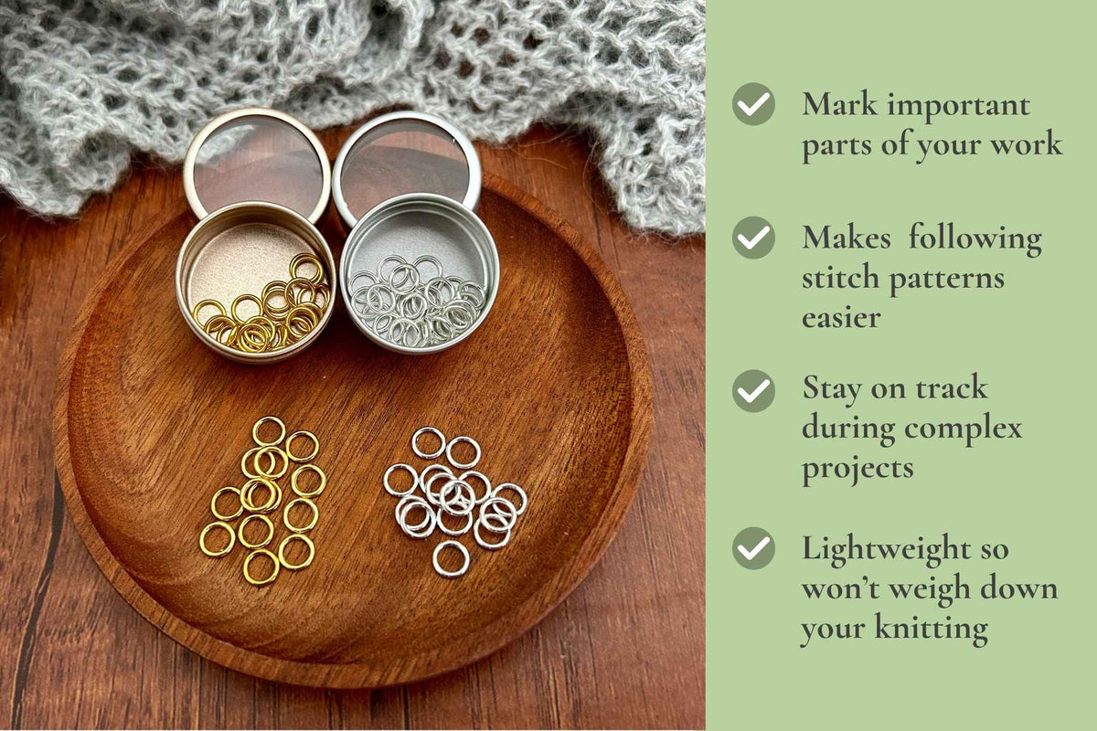 Two small round metal tin organisers filled with snag stitch markers rings, shown on a wooden tray beside a green text panel listing benefits such as marking important parts, making stitch patterns easier, staying on track, and being lightweight.