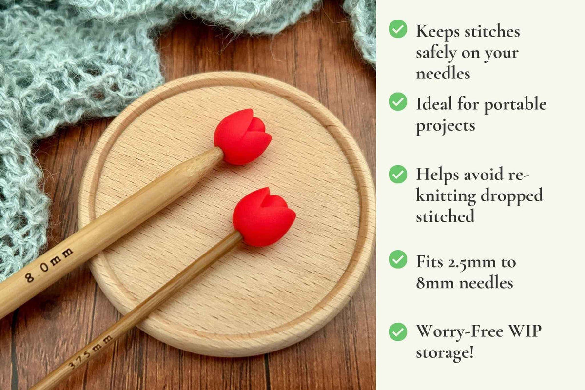Two wooden knitting needles with red tulip-shaped stitch saver tips tips rest on a round wooden tray beside a knitted fabric, with a text panel on the right listing benefits such as protecting stitches and suitability for portable projects.Keeps stitches on needles. Ideal for portable projects. Helps avoid re-knitting dropped stitches. Fits mm to 2.5mm to 8mm needles 
